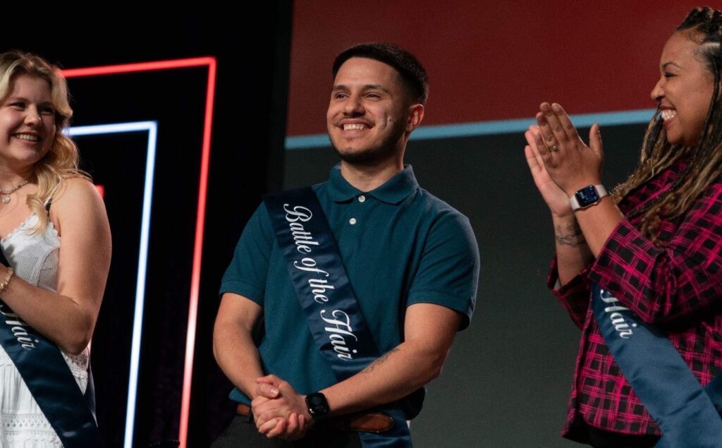 Battle of the Hair Winners Anna, Pablo, and Talisa on stage at the Sport Clips National Huddle for the announcement of the $5000 scholarship.